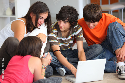 Foto jeunes garçons et filles assis devant un ordinateur portable