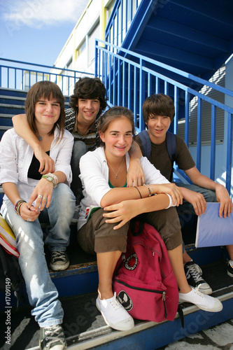 Adolescents souriants assis sur les marches avec documents