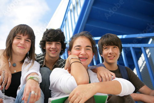 Adolescents souriants assis sur les marches avec documents photo