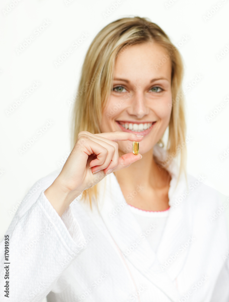 Attractive young woman holding a yellow pill Attractive young woman holding a yellow pill