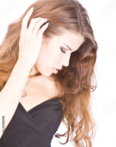 romantic young woman touching her long brown hair