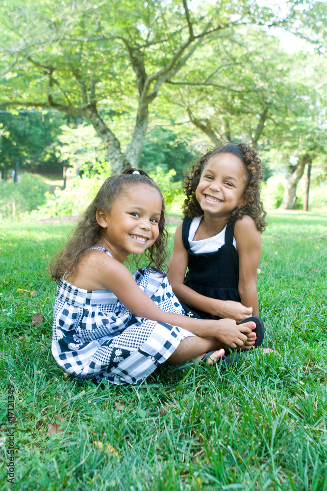 Two beautiful mixed race sisters enjoying the park Two beautiful mixed race sisters enjoying the park
