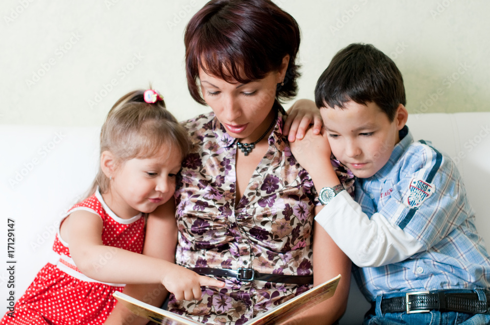 a mother is reading a book to her kids a mother is reading a book to her kids