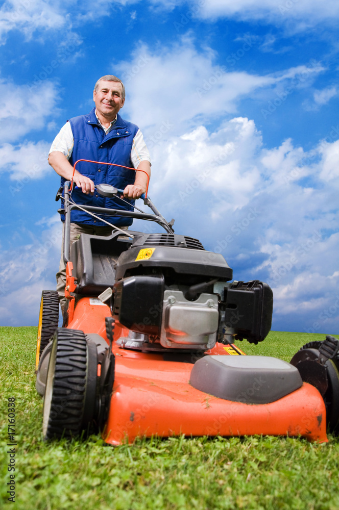 Fototapeta premium Senior man mowing the lawn.