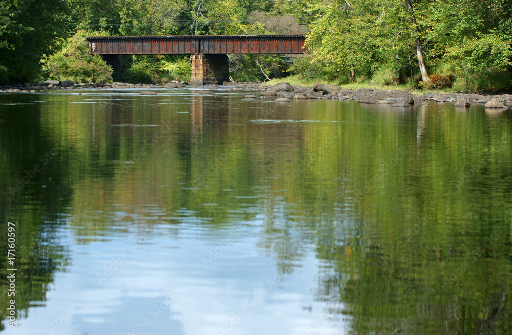 Peaceful river with railroad bridge