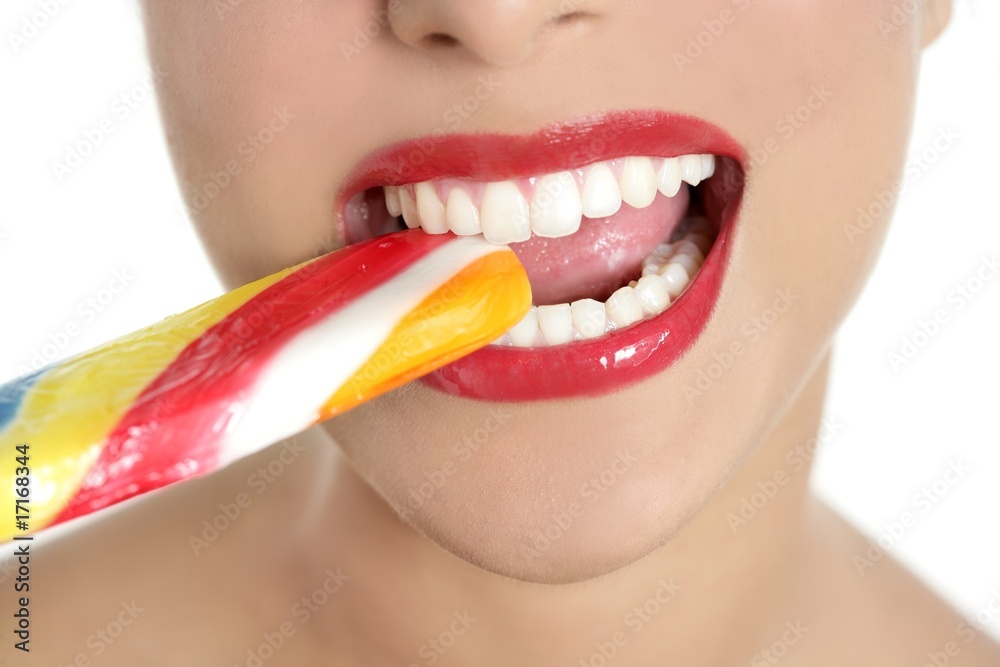 Fototapeta premium Colorful Lollypop in perfect woman teeth