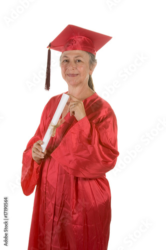Senior woman with in graduation gown with diploma