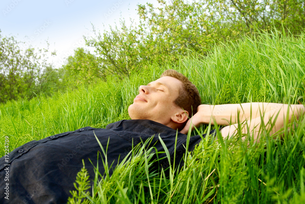 young man relax in spring grass young man relax in spring grass