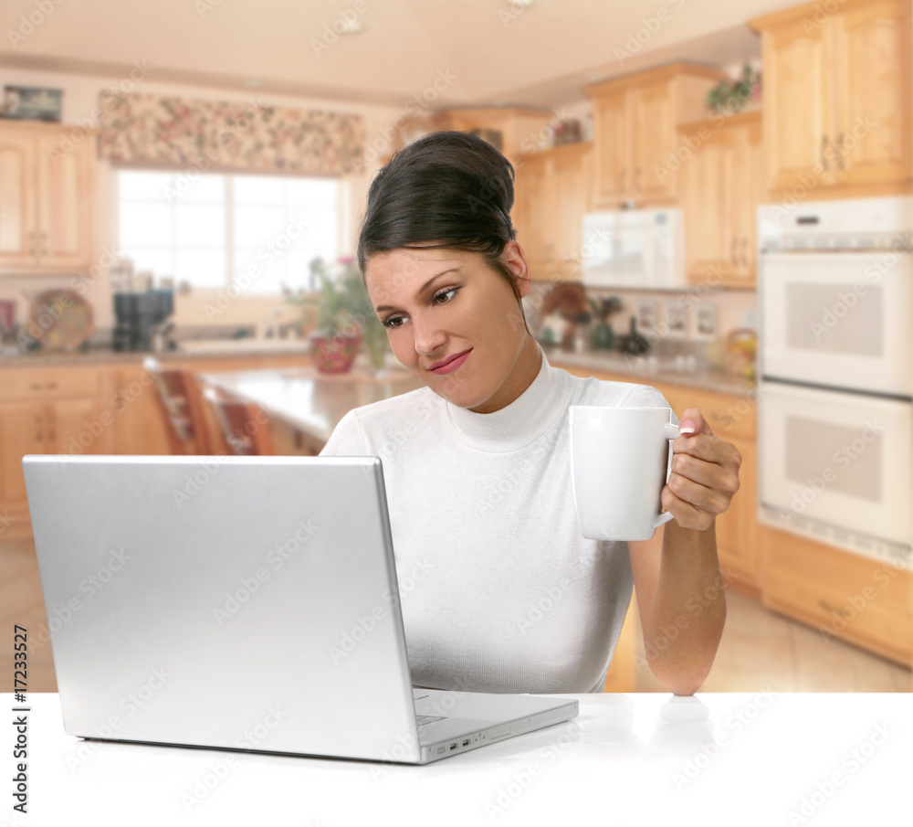 Young Woman Holding Coffee While Working on Her Laptop Computer Young Woman Holding Coffee While Working on Her Laptop Computer