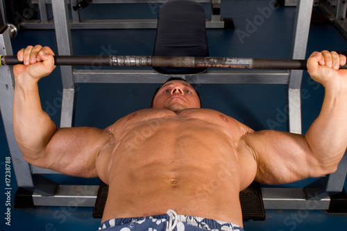 Bodybuilder training in the gym -bench press photo