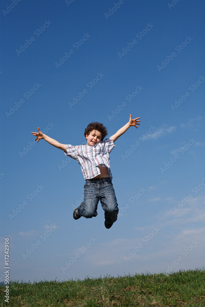 Boy jumping, running against blue sky Boy jumping, running against blue sky