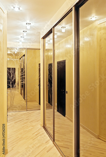Passage with a mirror wardrobe in warm tones