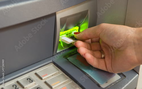 Inserting plastic card visa into ATM photo