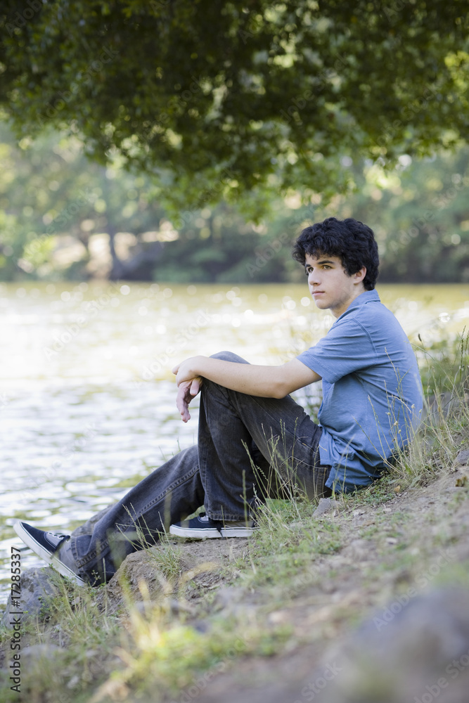 Teen Boy Sitting By Lake