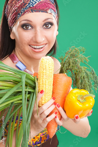 Pretty girl with vegetables on the green background photo