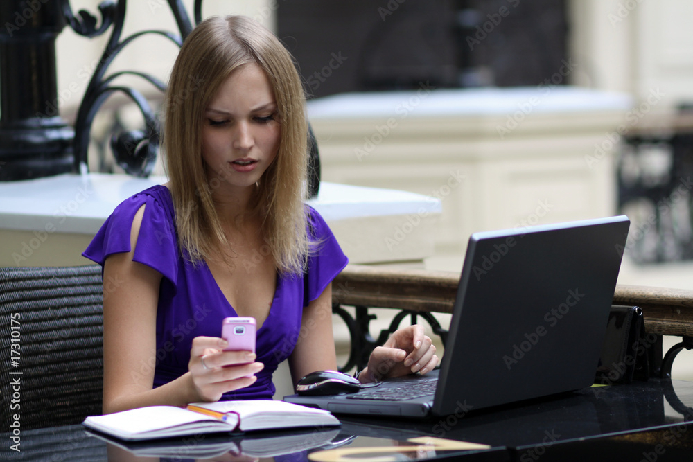 Young woman working on laptop in a cafe