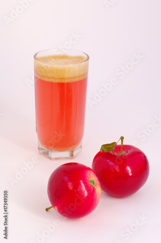 red apples and glass with juice on back plane