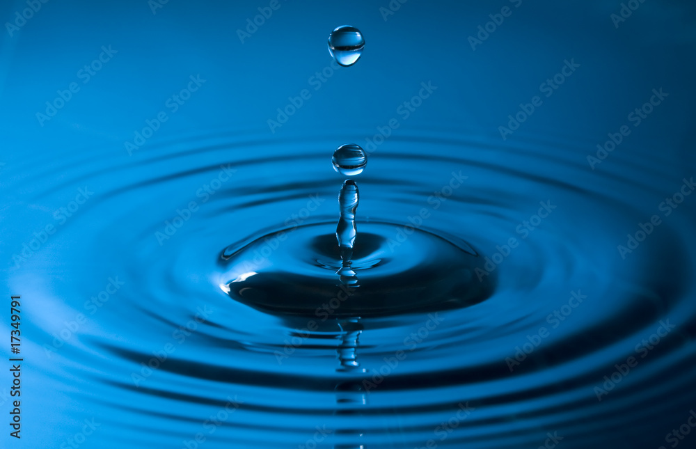 close up of a drop of water in blue colors close up of a drop of water in blue colors