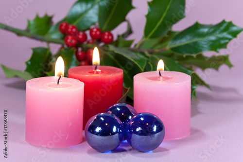 christmas decoration with candle light holly leaves and berries