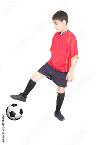 young boy playing football over white