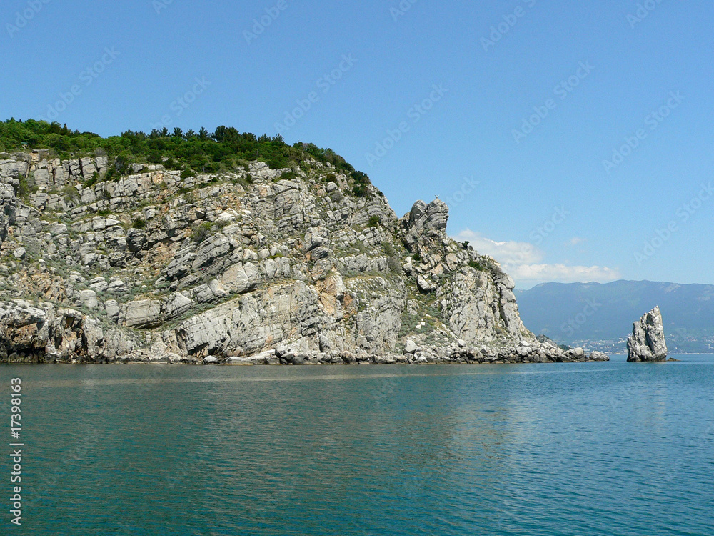 Mountains and an isolated rock in the blue sea