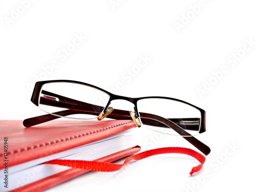 Red book and glasses isolated on white