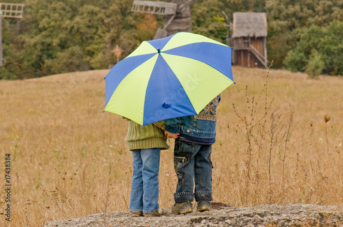 Little boy and girl with umbrella