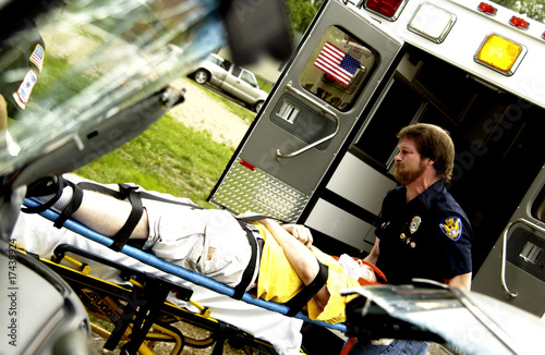 EMTs loading patient into ambulance photo