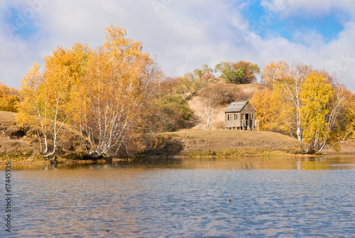 Colorful trees and wooden hut by a lake