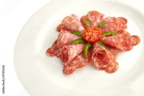 salami on white plate close up