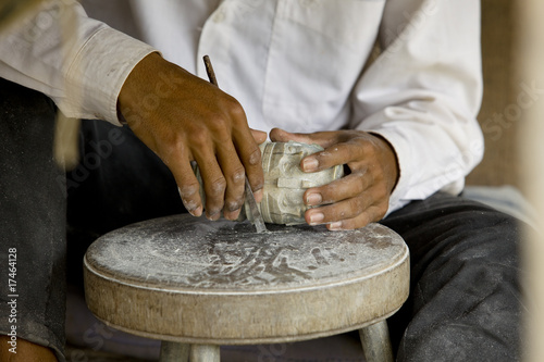 male hands carving a stone in cambodia