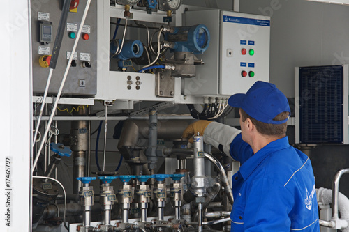 Worker standing at control sensors of a truck for cooled liquids
