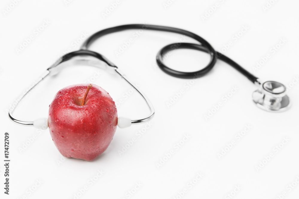 Red apple wearing stethoscope over white