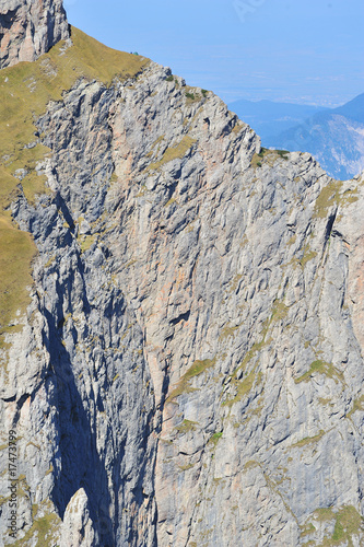 Man with tent on top of rock wall with blue haze in background