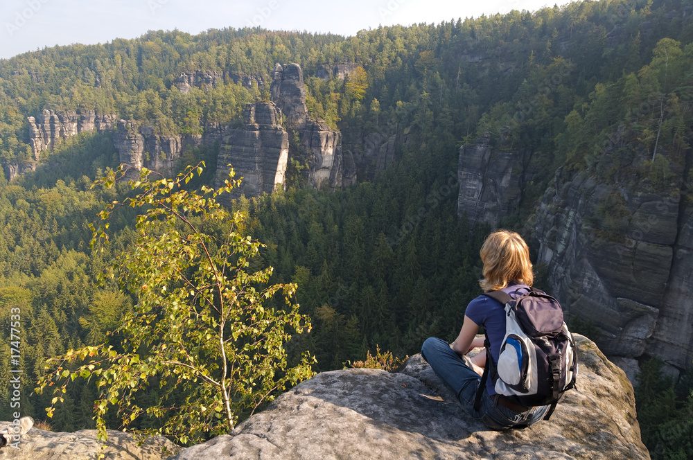 Frau sitzt auf Felsen an der Ida Grotte im Elbsandsteingebirge