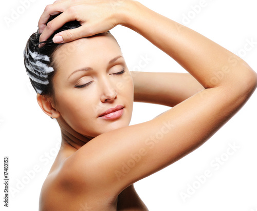 woman washing her head with shampoo photo