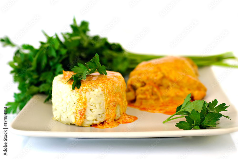 Rice with paprika chicken sauce and parsley on plate