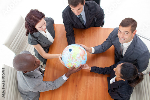 High Angle of businessteam holding a globe and businessman smili photo