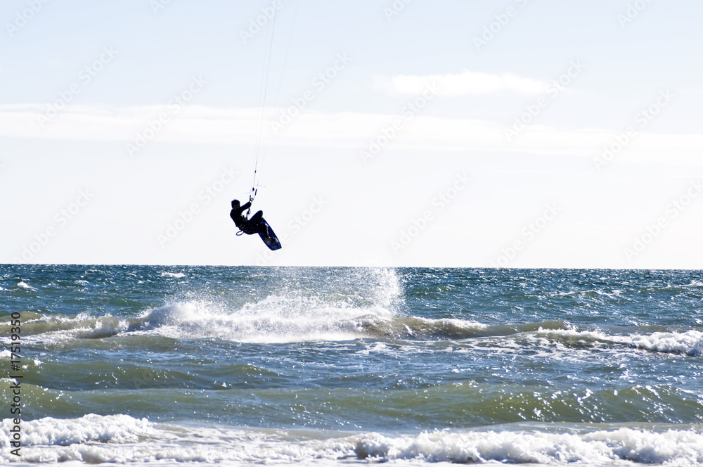 Silhouette of a kite-surfer jumping