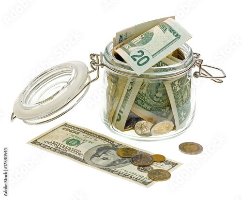 Different money in the glass jar isolated on white