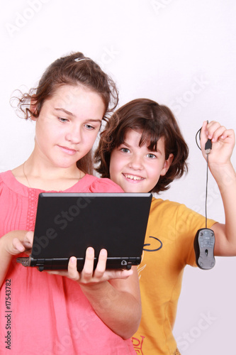Two attractive sisters with computer on white background