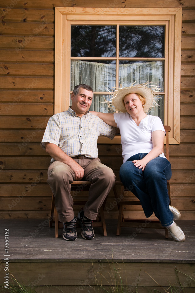 Senior couple having a rest on a terrace in front of house Senior couple having a rest on a terrace in front of house