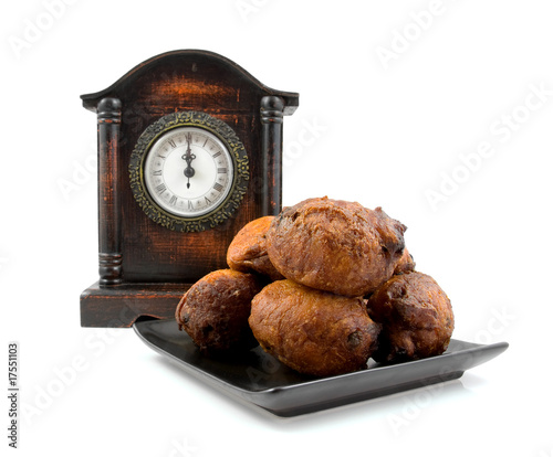 Dutch donut oliebollen and clock over white background photo
