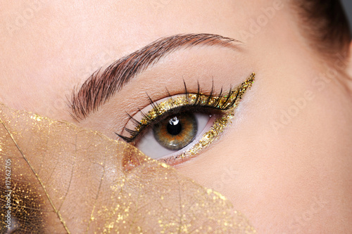 Foto Female eye with a golden arrow make-up