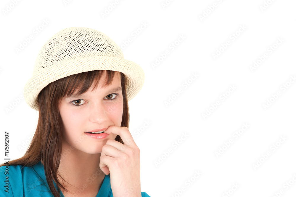 Portrait of young teenage girl in hat with finger in mouth