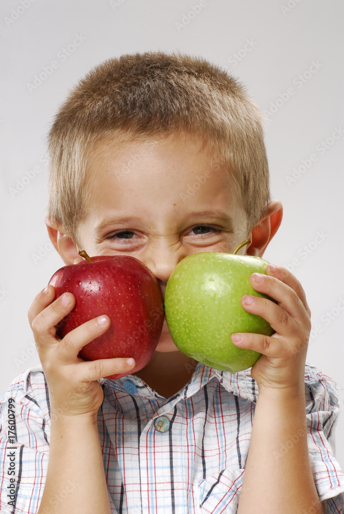 One little boy holding two apples. One little boy holding two apples.