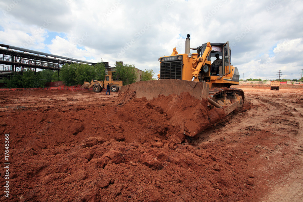The heavy building bulldozer of yellow color The heavy building bulldozer of yellow color