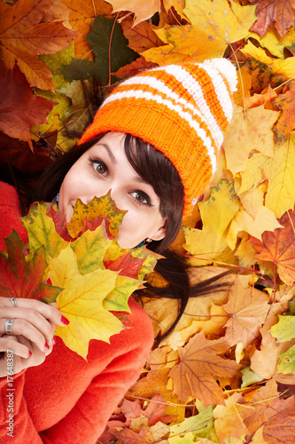 Girl in autumn orange hat on leaf group.Outdoor.