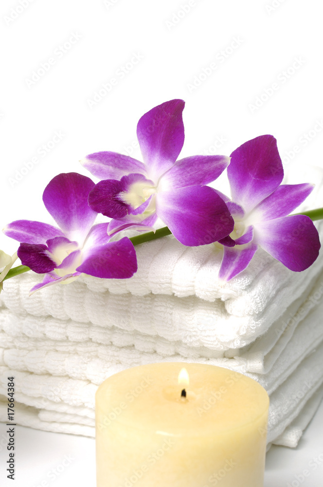 A beautiful orchid , towel and candle