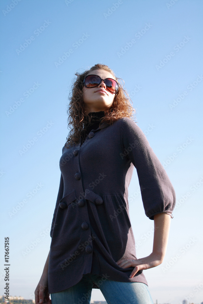 girl poses against the blue sky